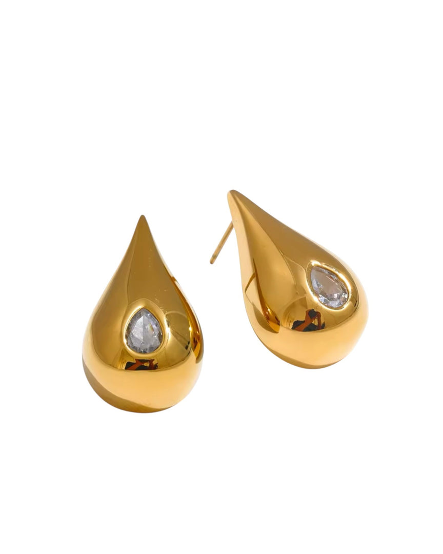 Luxurious gold teardrop earrings featuring a sparkling crystal inset, creating a radiant and sophisticated look. From Lia Haddi.