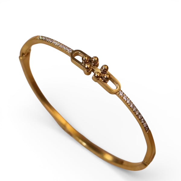 Gold bangle bracelet with pavé crystals and decorative link centerpiece