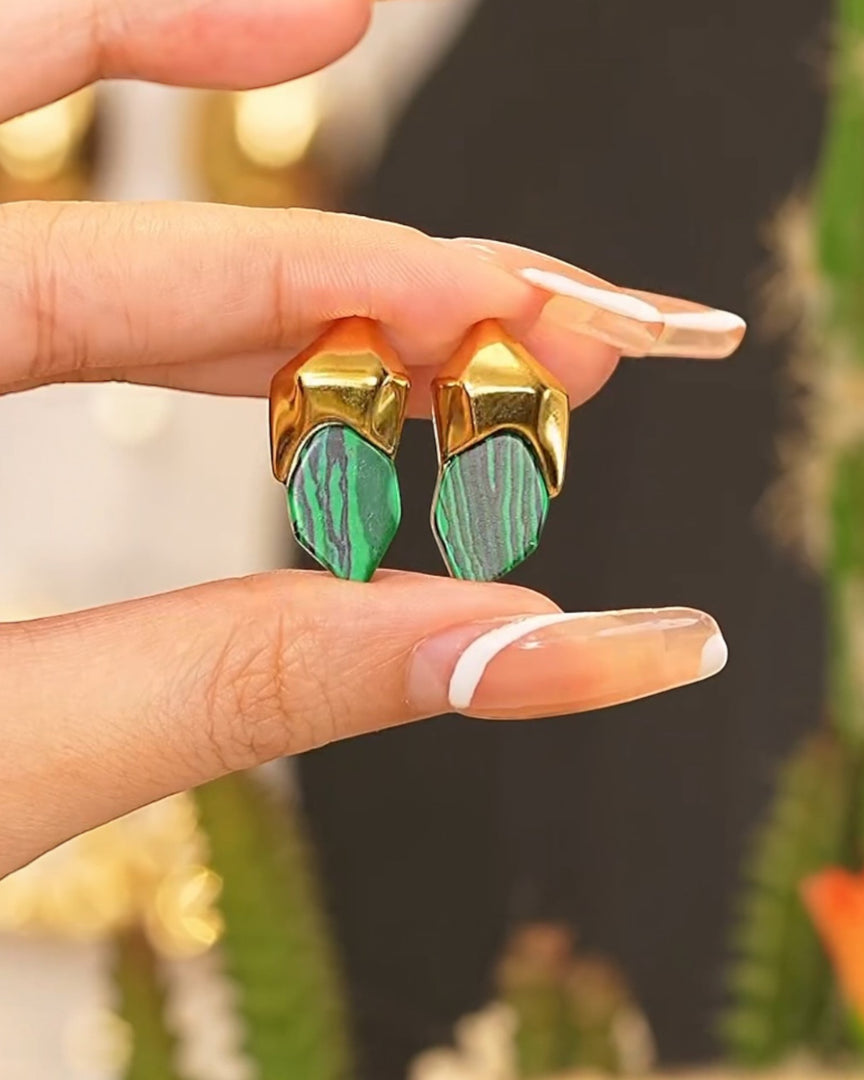 Bold emerald-patterned stud earrings encased in gold-toned geometric frames, exuding modern elegance. From Lia Haddi.