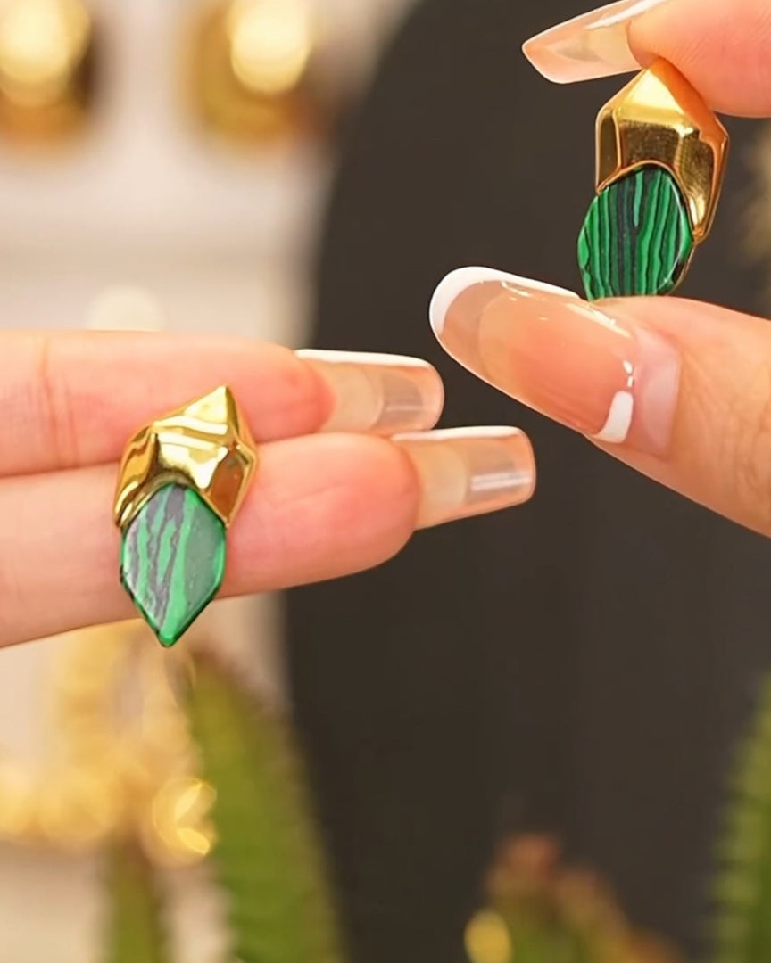 Bold emerald-patterned stud earrings encased in gold-toned geometric frames, exuding modern elegance. From Lia Haddi.