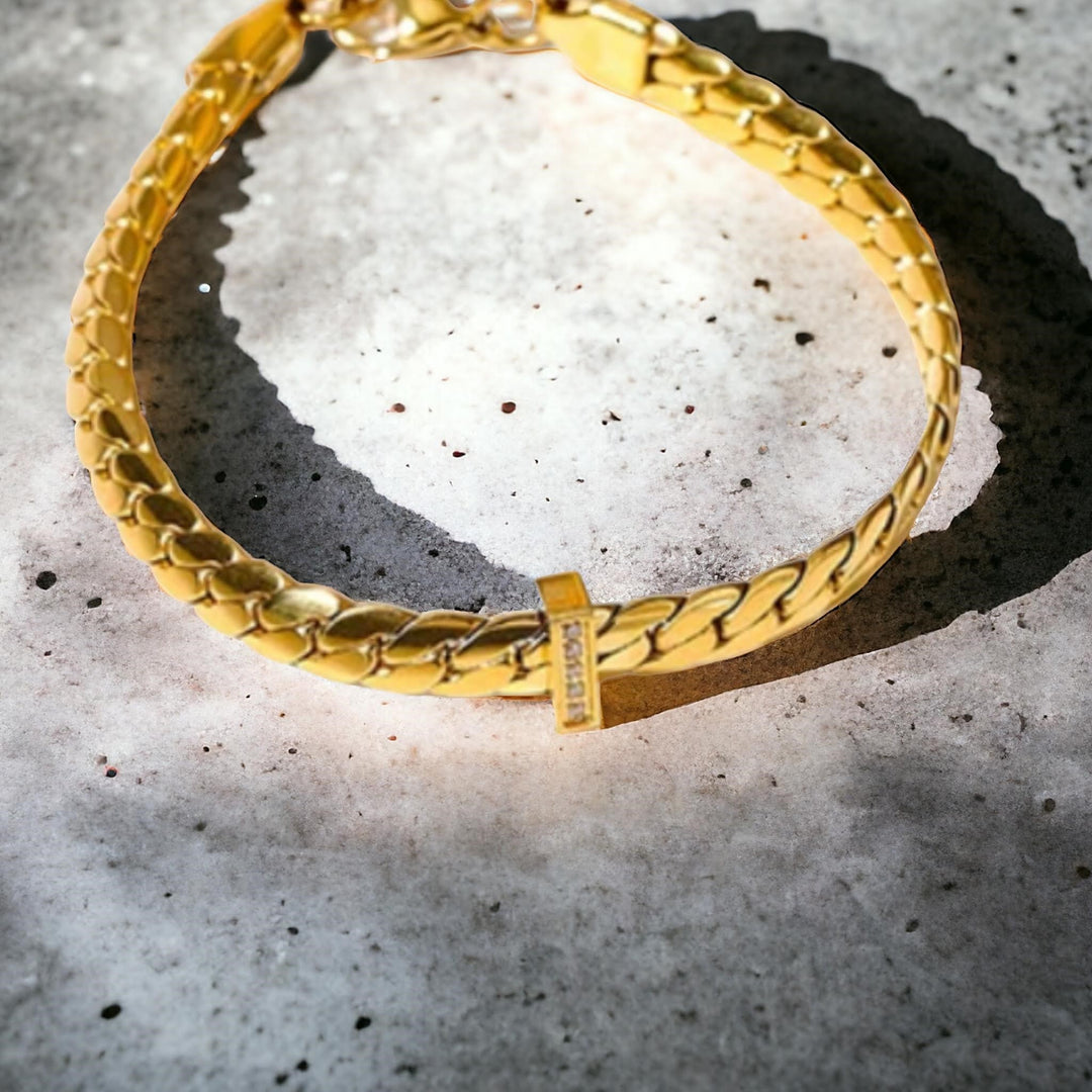 Golden Herringbone Bracelet - Elegant gold bracelet with a herringbone pattern and a central cross detail, perfect for a sophisticated look.