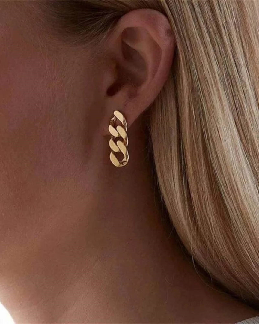 Gold Cuban chain drop earrings featuring bold interlinked design for a statement look. From Lia Haddi.